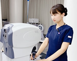 北村医師が顕微鏡を覗く様子