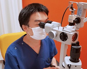 北村医師が顕微鏡を覗く様子